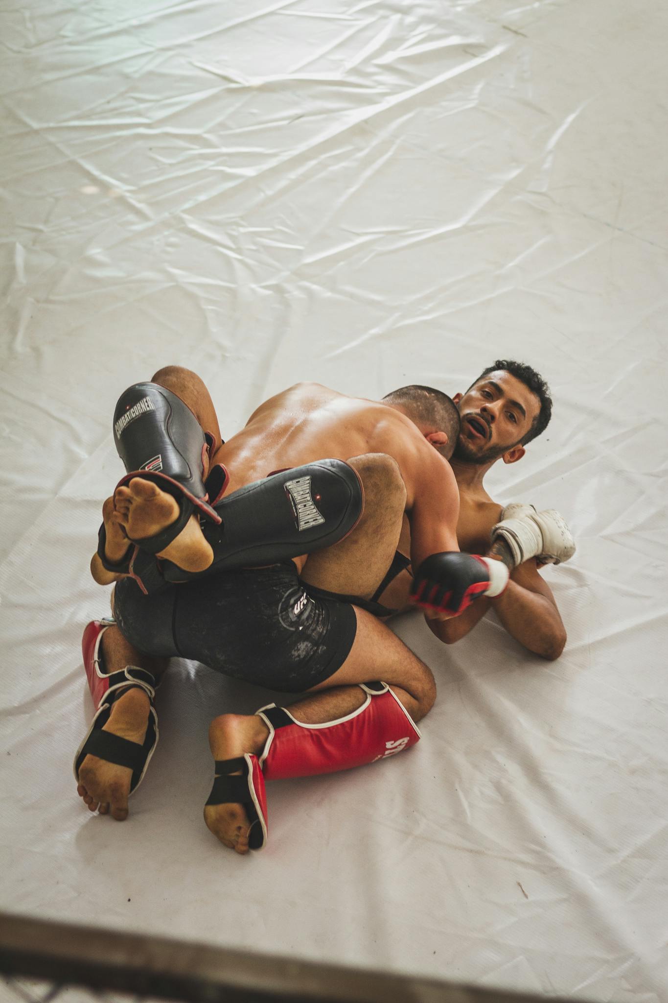 Two men engage in Brazilian jiu-jitsu grappling, showcasing skill and technique.