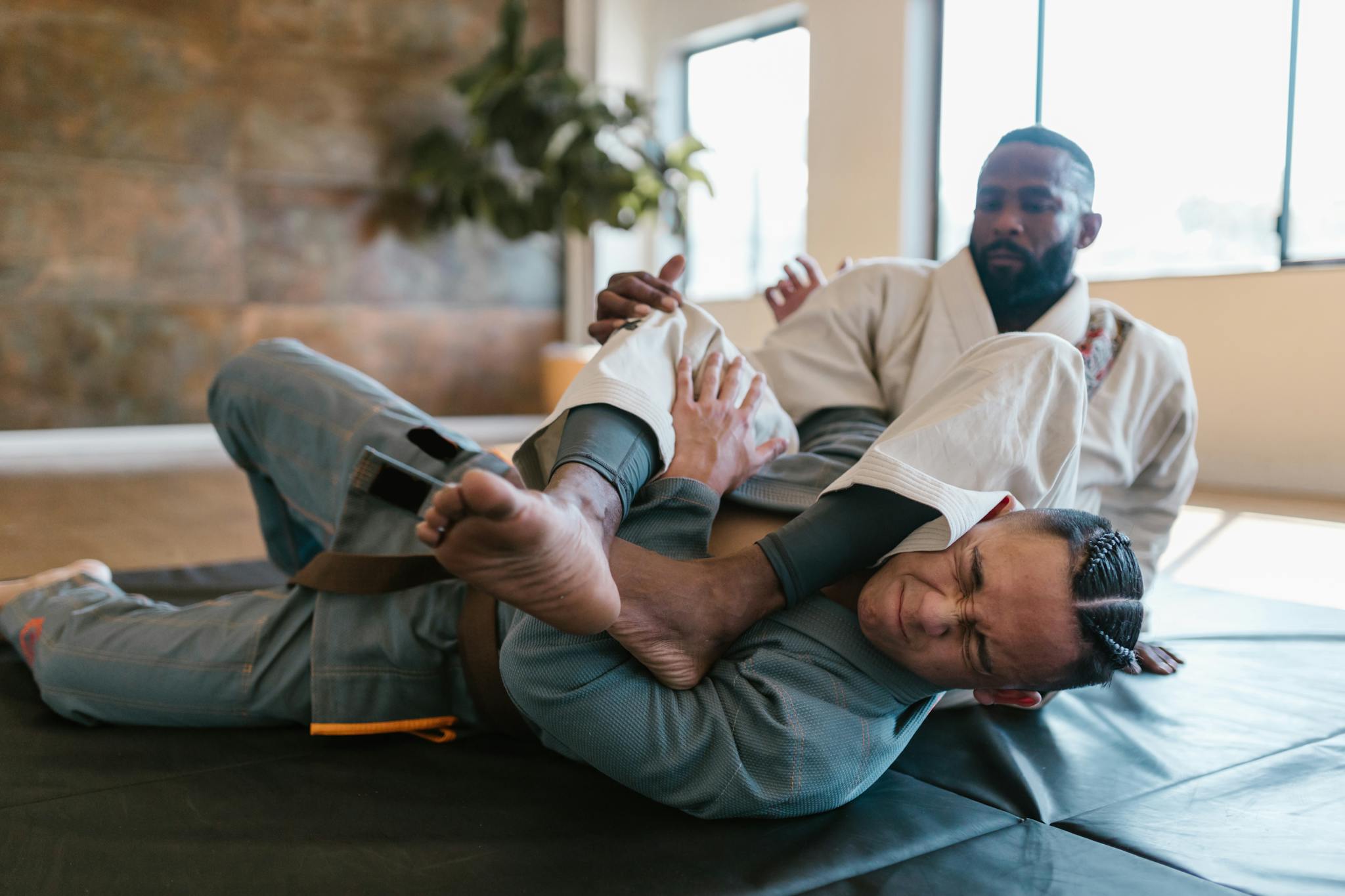 Two men practicing martial arts sparring indoors with focus on technique.